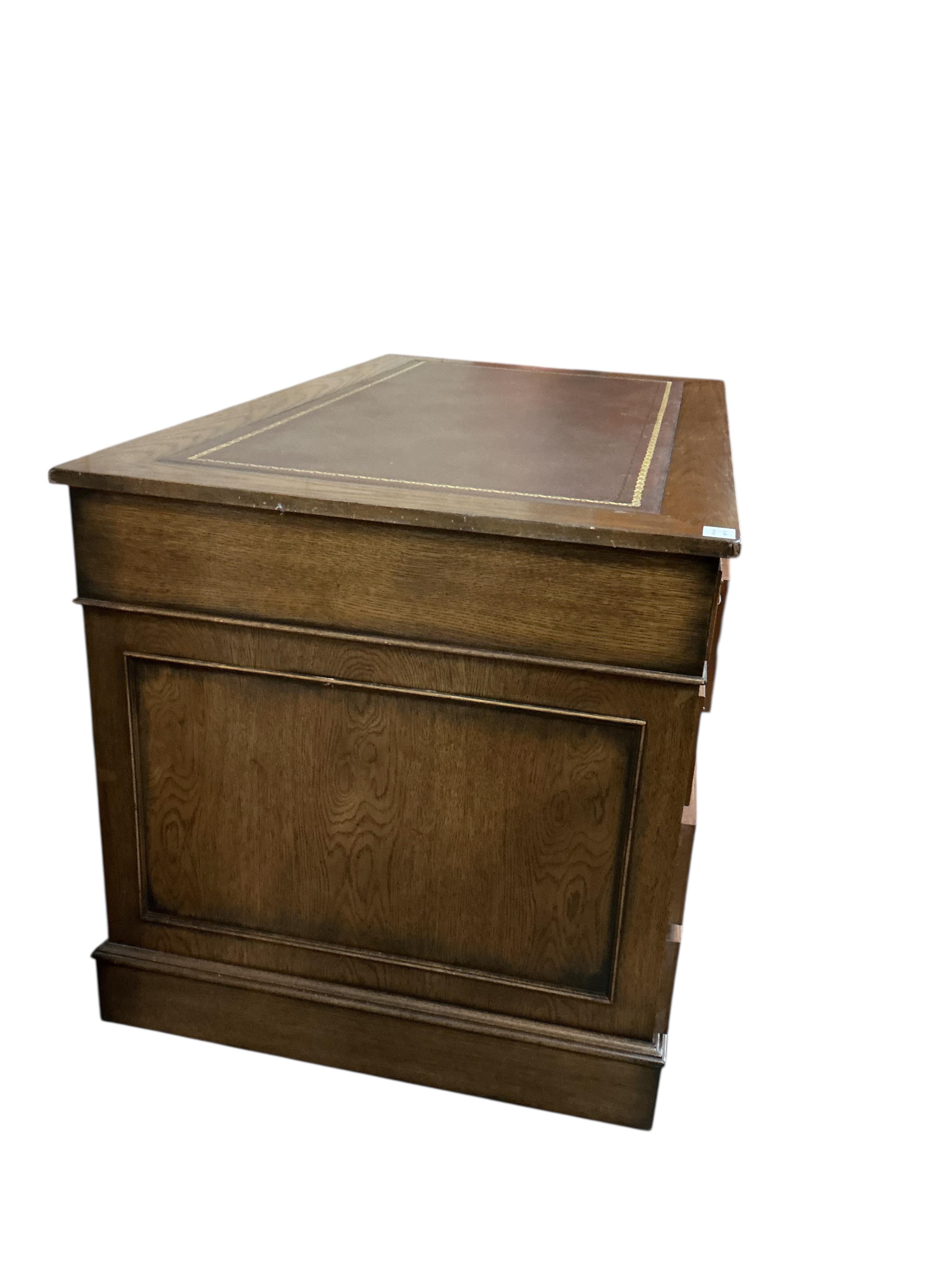 A reproduction oak pedestal desk, width 137cm, depth 76cm, height 78cm